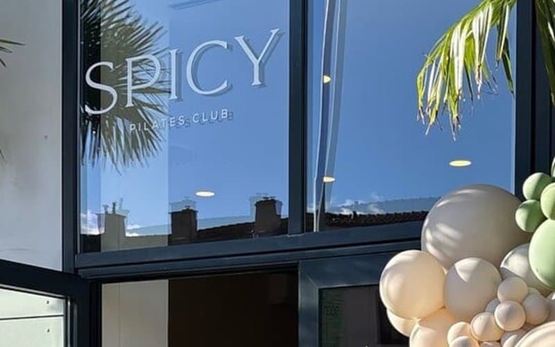Vchod do štúdia Spicy Pilates Club s logom na presklenej fasáde